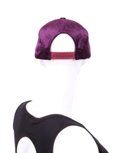 Load image into Gallery viewer, The Purple Velvet Tennis Hat exudes a unique blend of elegance and sporty charm. Crafted from a plush and rich purple velvet material, this hat sets itself apart with its luxurious texture and vibrant color. The velvet fabric catches the light in a way that creates subtle shifts in hue, adding depth to the overall appearance.