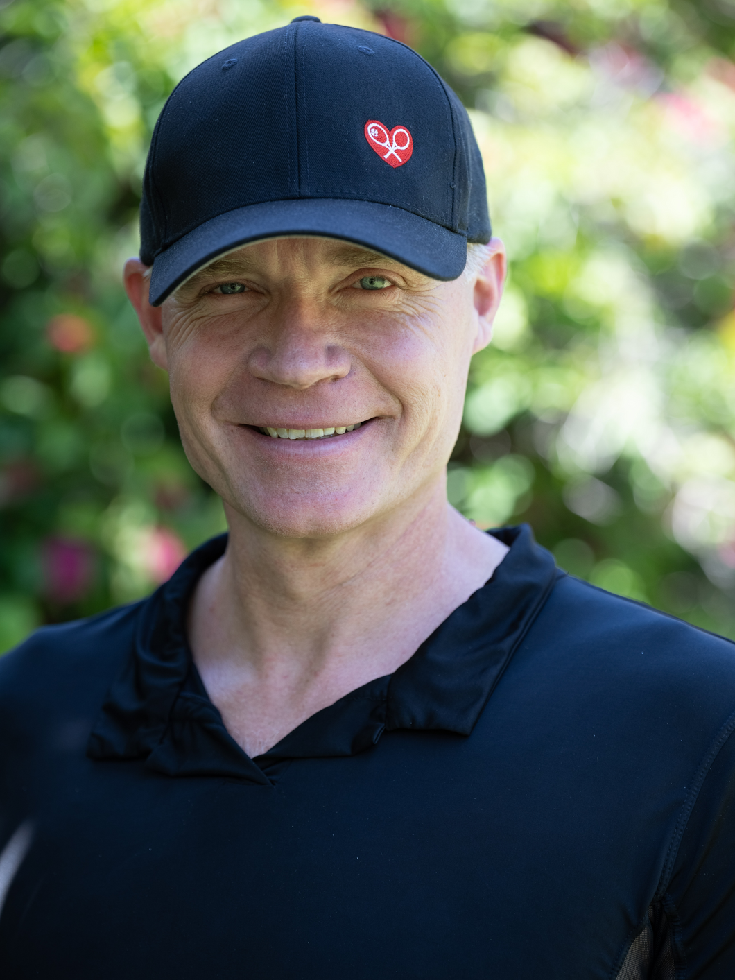 Black Trucker Hat with Heart + Rackets is a unique and eye-catching accessory that beautifully combines sporty aesthetics with a touch of emotion and symbolism.