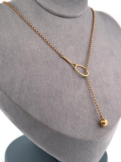 The newest design by Adeline - this unusual necklace is a tennis lovers delight.   The solid gold ball threads through the racket and can be worn higher or lower on the neck.  This piece was hand made in the jewelry district of Los Angeles by a fine jewel craft team.  The racket is 1" long and the ball is 6mm around.  Light yet strong enough to play (and win) in.